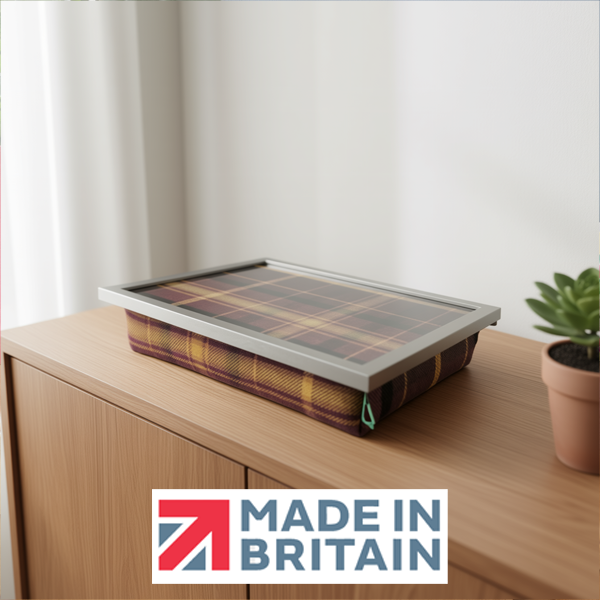 The Papillon Tweed lap tray with a cushioned base and silver frame, displayed on a wooden cabinet, alongside the Made in Britain logo.