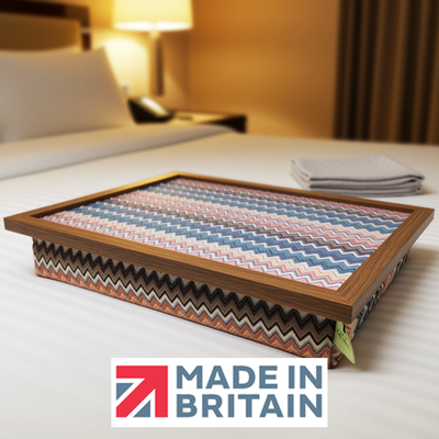 The Valencia lap tray with wooden frame and a cushioned base, displayed on a neatly made bed, alongside the Made in Britain logo.